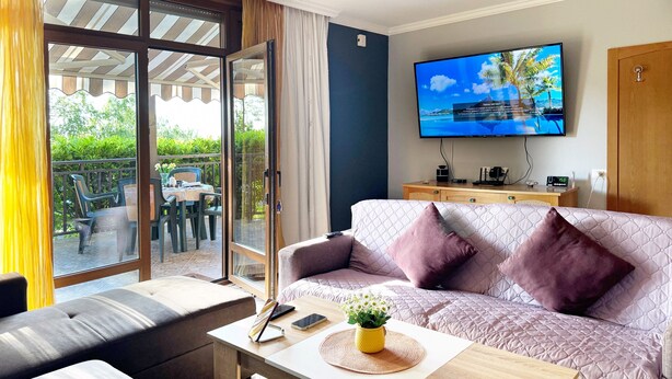 A modern living room with a sofa, a coffee table, and a TV on the wall. - Stunning 2-bed Apartment in Sozopol (Sozopol)