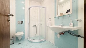 A modern bathroom with a glass shower enclosure, a white sink with a soap dispenser, and a toilet. - Stunning 2-bed Apartment in Sozopol (Sozopol)