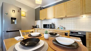 A modern kitchen with a stainless steel refrigerator, a microwave, a coffee maker, and wooden cabinets. - Stunning 2-bed Apartment in Sozopol (Sozopol)