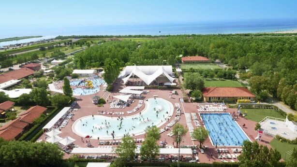 An aerial view of a resort with multiple swimming pools, a large white building, and a beach in the background. - Barricata Holiday Village Lodge Tent Deluxe für 5 Personen (Porto)
