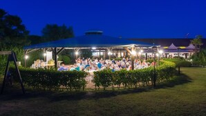 An outdoor dining area with tables and chairs under a covered pavilion. - Barricata Holiday Village Lodge Tent Deluxe für 5 Personen (Porto)