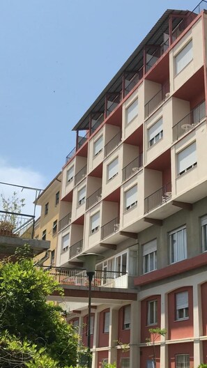 Edifício residencial com várias andares, varandas e janelas.