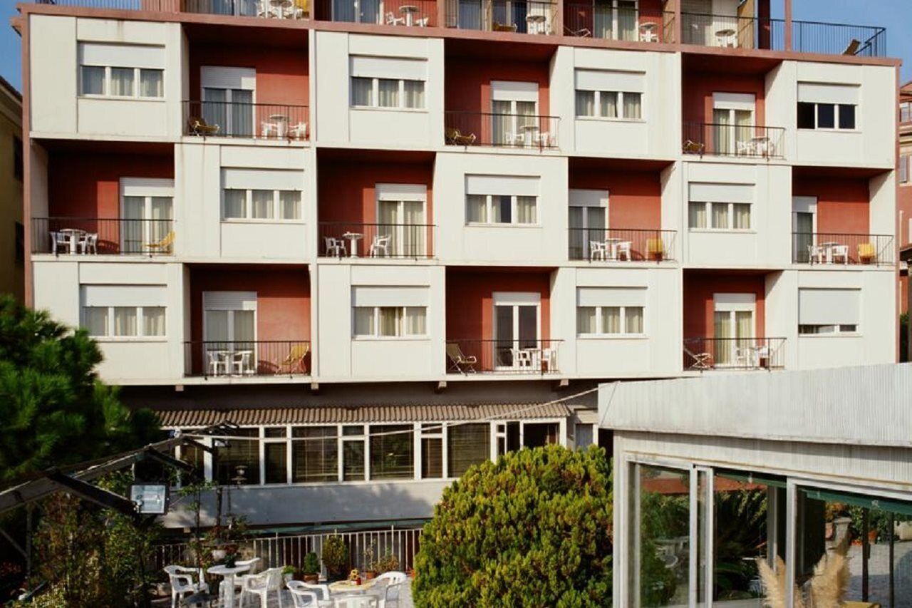 Un hotel a più piani con balconi, posti a sedere all'aperto e un tetto piano.