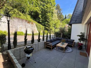 En uteplats med en grill, en soffa och ett bord.