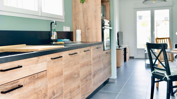 A modern kitchen with wooden cabinets, a black countertop, and a window above the sink. - Detached house with jacuzzi (La Sauvetat-du-Dropt)
