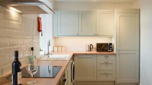 A kitchen with a sink, a microwave, and cabinets. - Stunning Sea Views in Central Burntisland (Burntisland)
