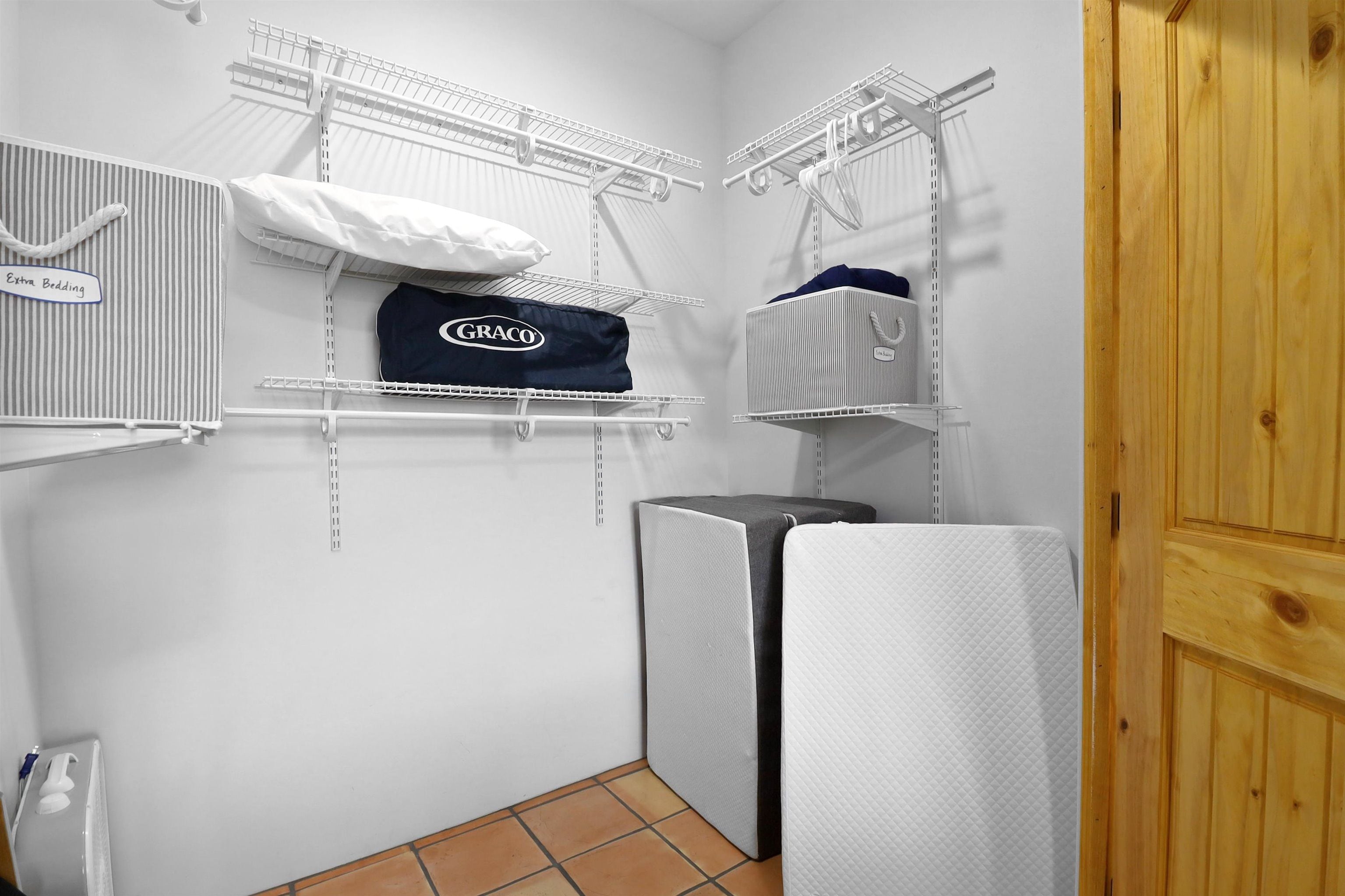 A laundry area with shelves for hanging clothes, a white radiator, and a wooden door.