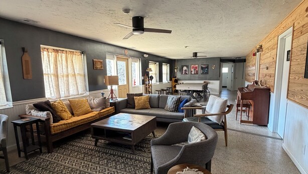 A spacious living room with a patterned rug, a sofa, a coffee table, and a dining area in the background. - 5min to Breweries and 25min to Tail of the Dragon. Pool table + pet friendly! (Andrews)