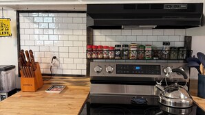A kitchen with white cabinets, a black range hood, a stainless steel stove, and a kettle. There are spices on the counter and a knife block. - 5min to Breweries and 25min to Tail of the Dragon. Pool table + pet friendly! (Andrews)