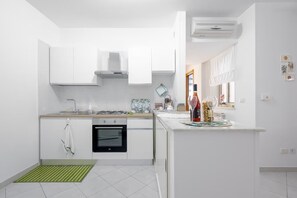 Un four, surface de cuisson, cafetière-théière, vaisselle et ustensiles