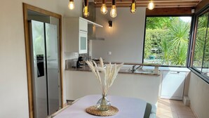 Una cocina moderna con comedor, que incluye una mesa blanca y sillas azul claro.