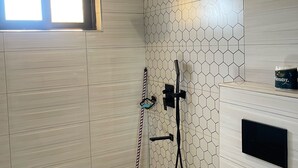 A modern bathroom with a shower, a toilet, and a window. - 1 Bed Flat - Sleeps 2 - Parking - Wifi (Kampala)