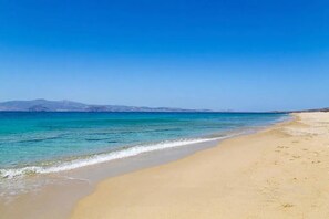 A beach with clear blue water and a sandy shore. - Villa Polemis (Naxos)