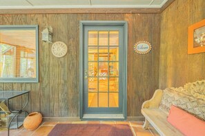 Cozy interior space with a wooden paneled wall, dark door, and a welcoming bench.