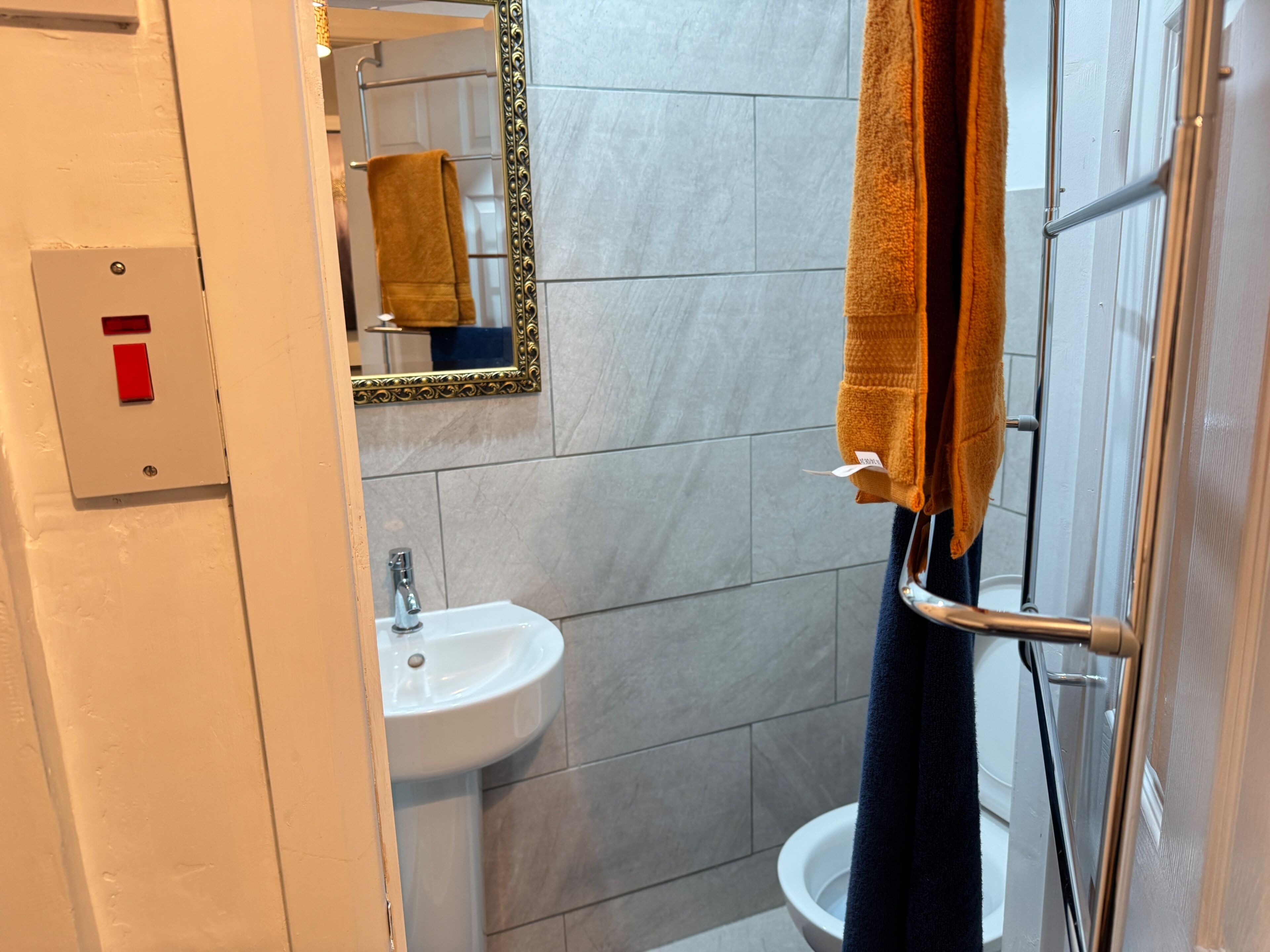 A bathroom with a white sink, a mirror, and a towel rack.