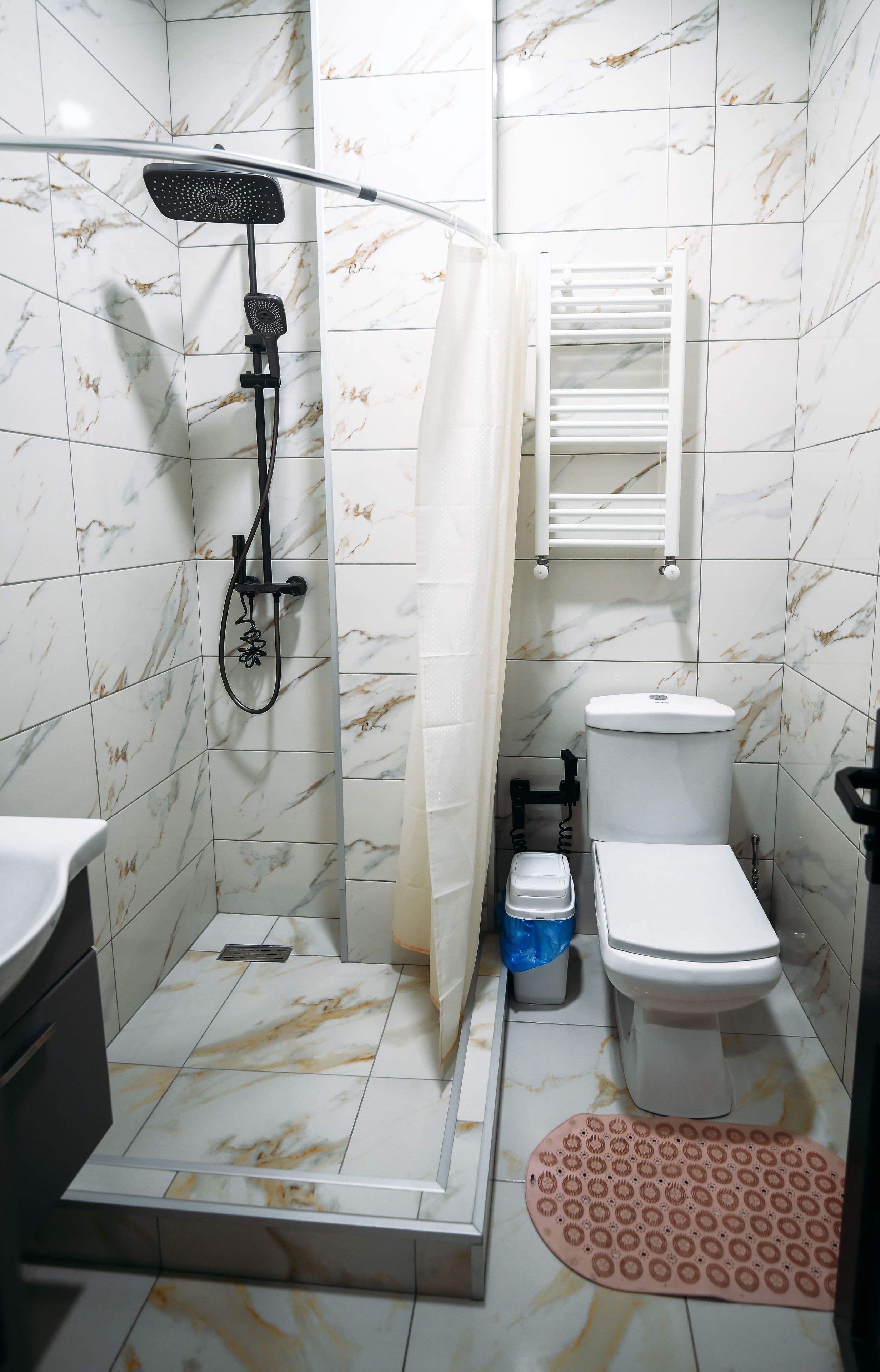 A bathroom with a shower, toilet, and sink.