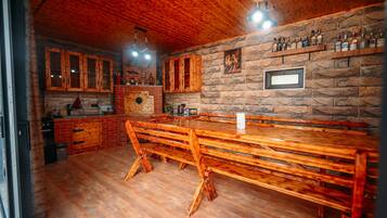 Un interior rústico con muebles de madera, paredes de piedra y una zona de bar.