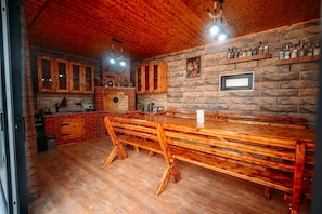 A rustic interior with wooden furniture, stone walls, and a bar area. - Prestige Guest House (Kutaisi)