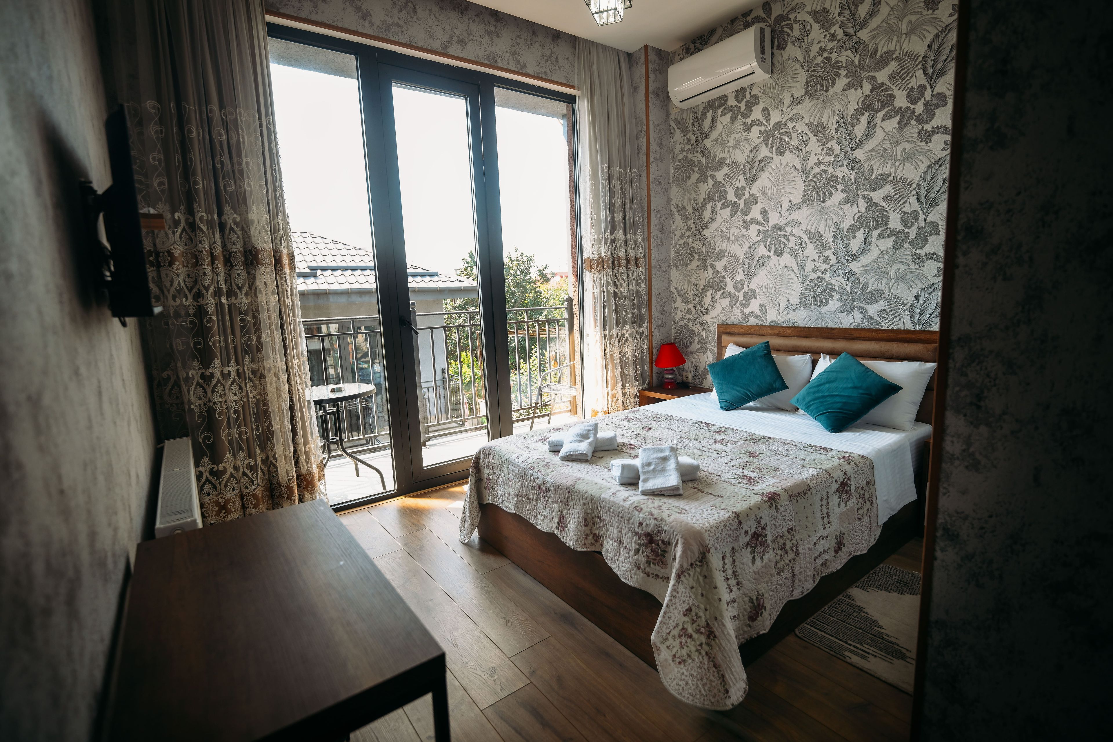 Une chambre d’hôtel avec un lit, une table, un balcon et une vue sur l’extérieur.