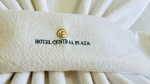 Toalla blanca con bordado que dice 'HOTEL CENTRAL PLAZA'.