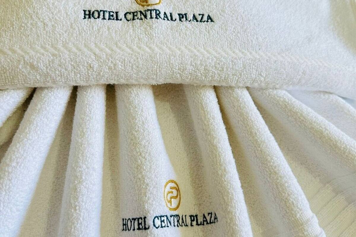 A white towel with embroidered text reading "HOTEL CENTRAL PLAZA".