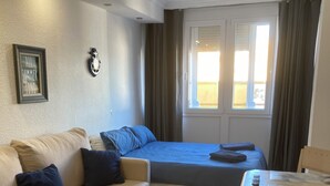A compact hotel room with a bed, a sofa, a small table, and a chair. - Benalmadena Beach Studio, Double bed, En Suite.  (Benalmádena)