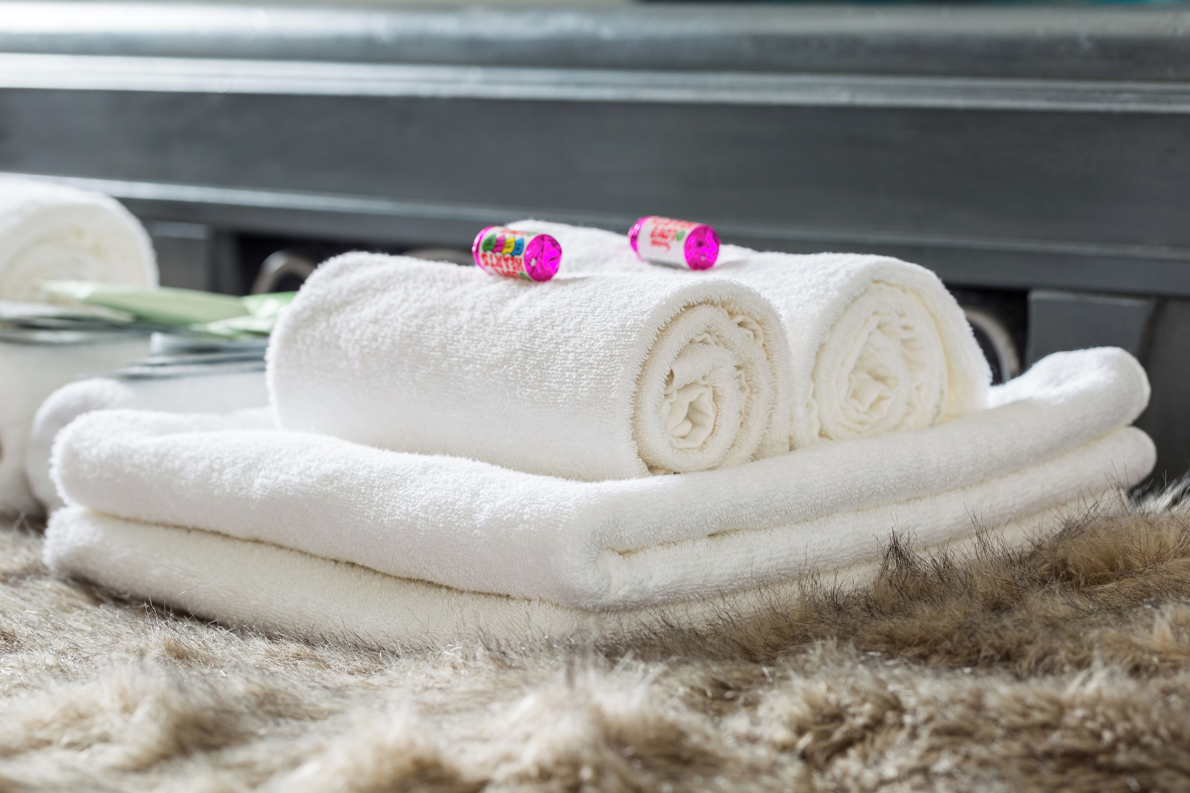 A stack of white towels on a fur-like surface.