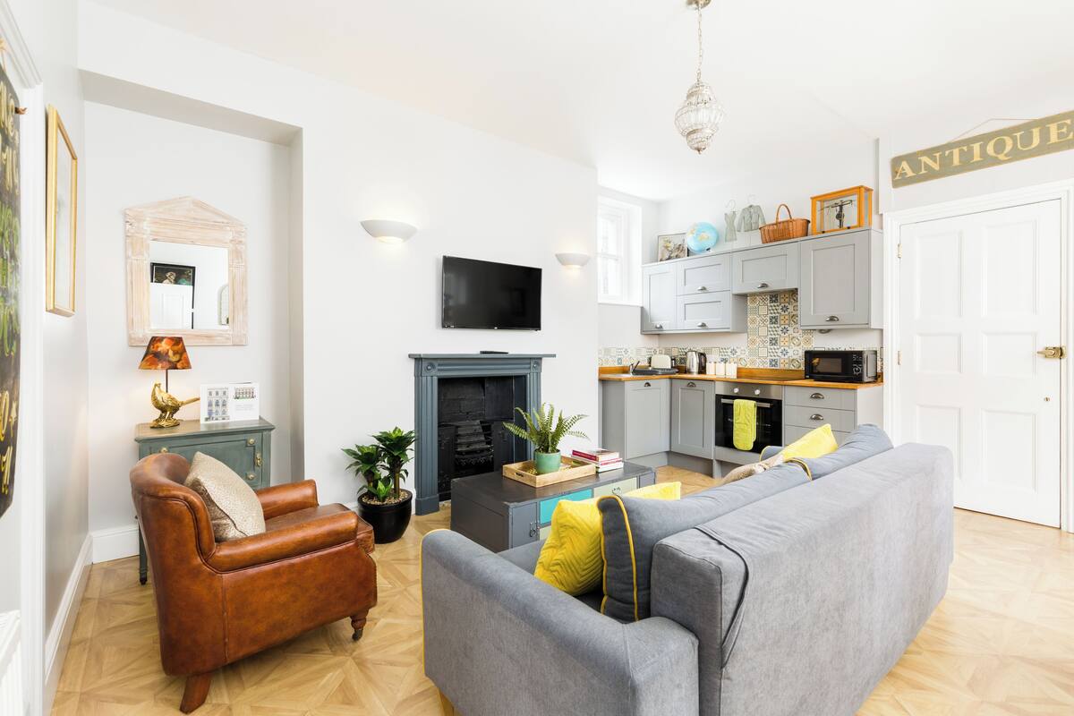 A living room with a fireplace, sofa, and a television.