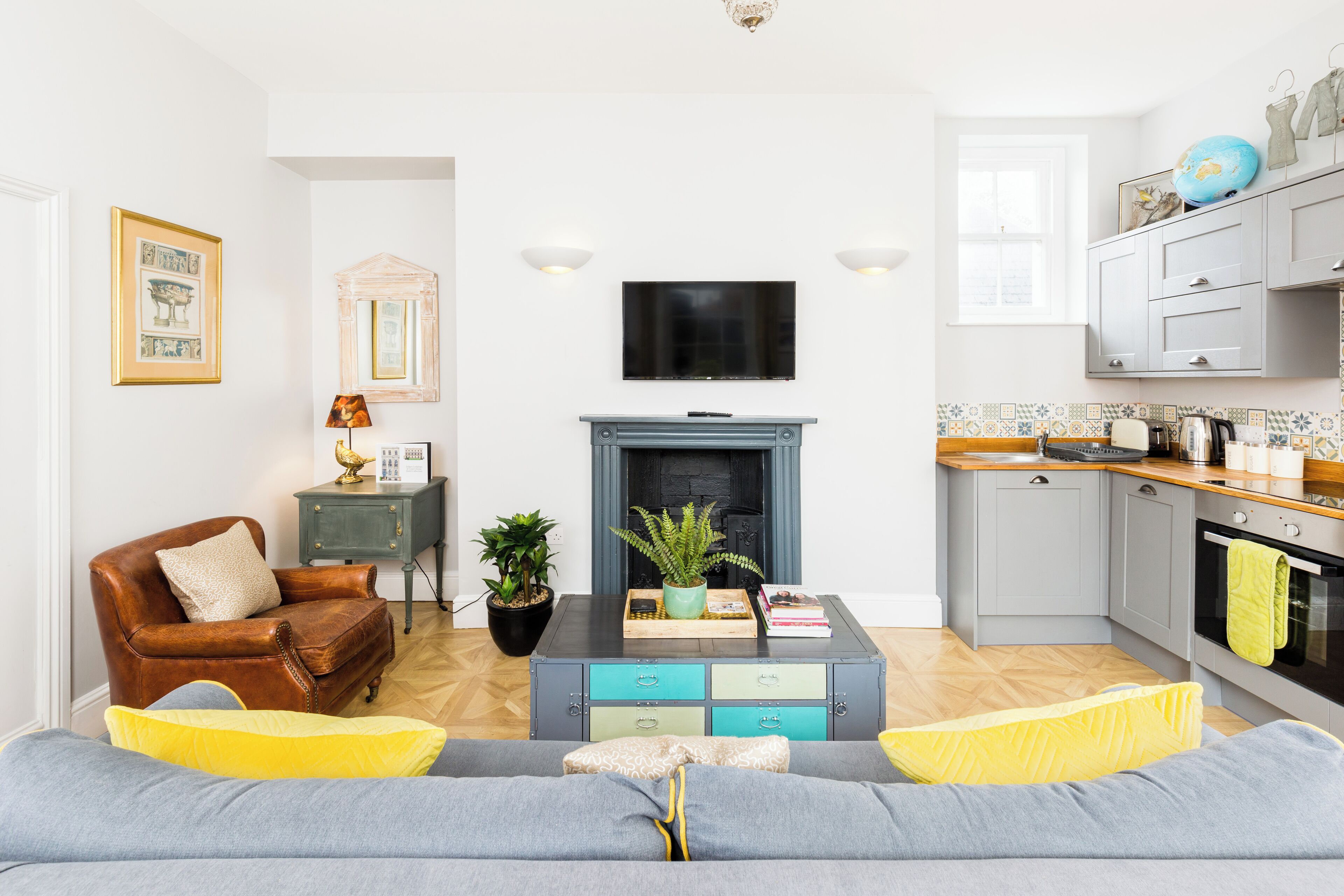 Una sala de estar con un sofá, una mesa de centro, una chimenea y un televisor.
