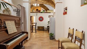 A cozy room with a piano, chairs, a dining table, and a brick ceiling. - Domus Gelsomino, St Peter's Square, Vatican, Central Rome (Rome)