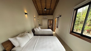 A room with two beds, wooden headboards, a ceiling fan, and a window with a view of greenery. - Mt. Plaisir Estate Hotel (Grande Riviere)