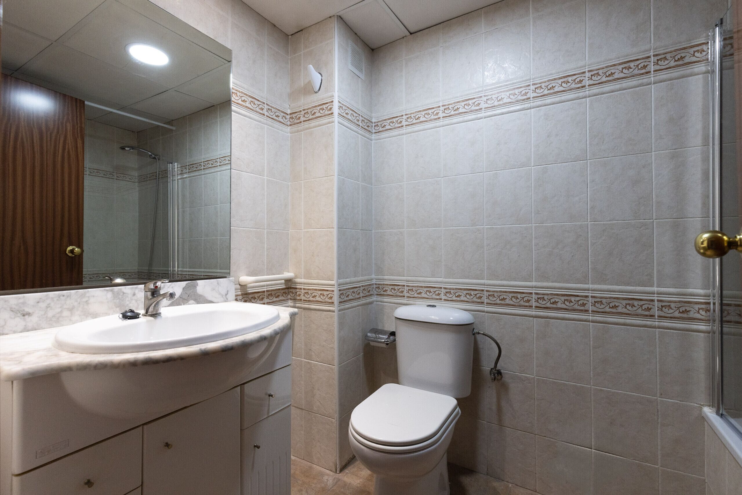 Une salle de bain équipée d’un lavabo, de toilettes et d’une douche.