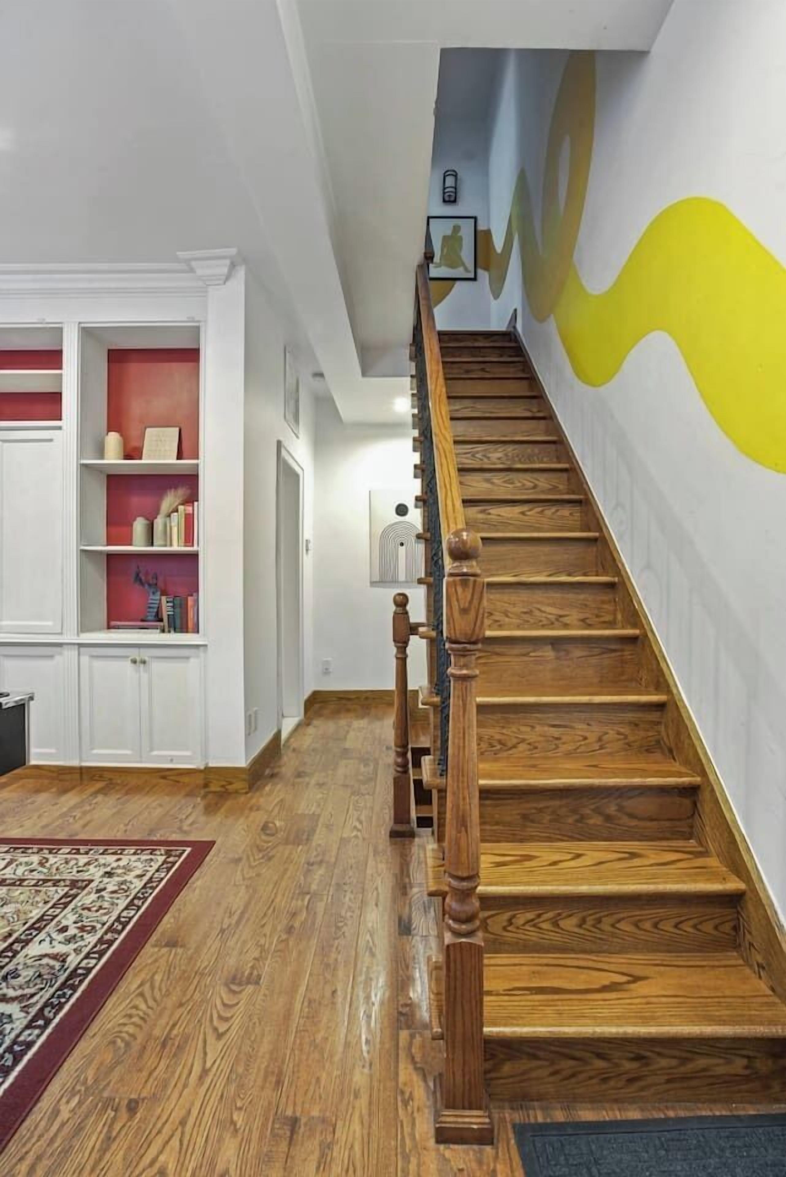 Una escalera de madera con barandilla que lleva a una plataforma.