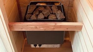 A wooden interior with a stone hearth and a drawer containing charcoal. - Peaceful space in the country. Deck&private indoor sauna. Surrounded by nature! (Horseheads)