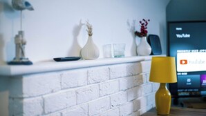 Ein Kamin aus weißen Ziegeln mit Dekoration und einer Lampe.