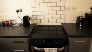 A kitchen with a stove, oven, and a glass-fronted range hood. - 20%OFF|MonthlyEscape|Family|Leisure|WiFi|Sleeps4 (Suffolk)