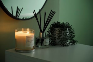 A hotel collection scented candle labeled 'Pomegranate' on a white surface.