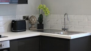 A kitchen with a built-in sink, a toaster, a decorative pineapple, and a potted orchid.