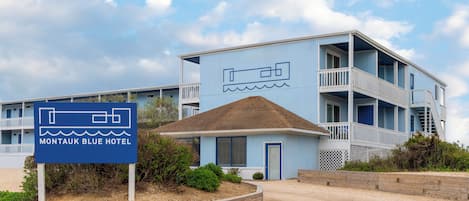 A two-story motel with a blue exterior and a sign indicating it is the Montauk Blue Hotel.