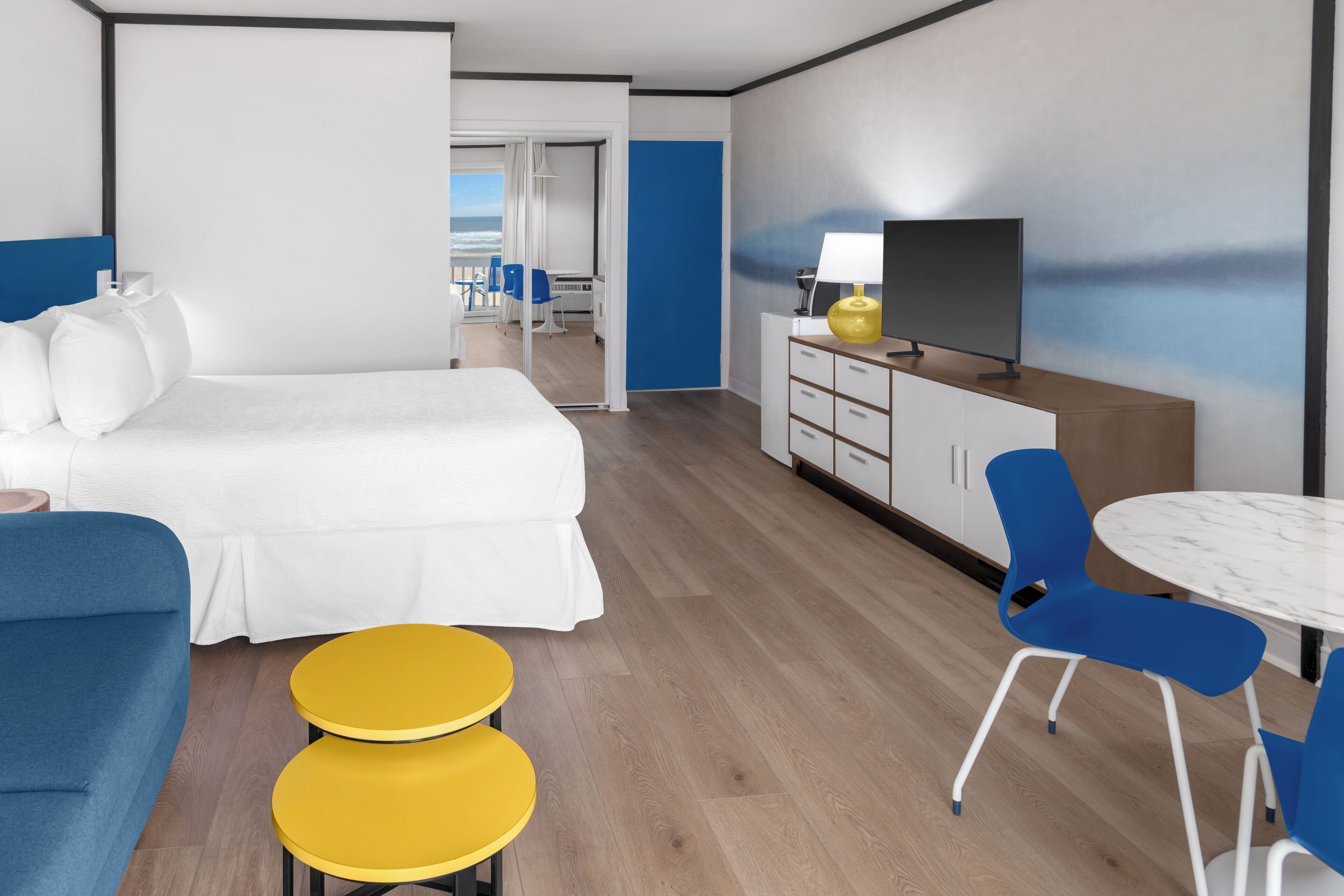 Une chambre d’hôtel moderne équipée d’un lit, d’un canapé, d’une télévision, d’un bureau et d’une chaise.