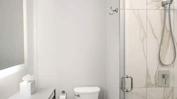 Uma casa de banho moderna com sanita, chuveiro e espelho.