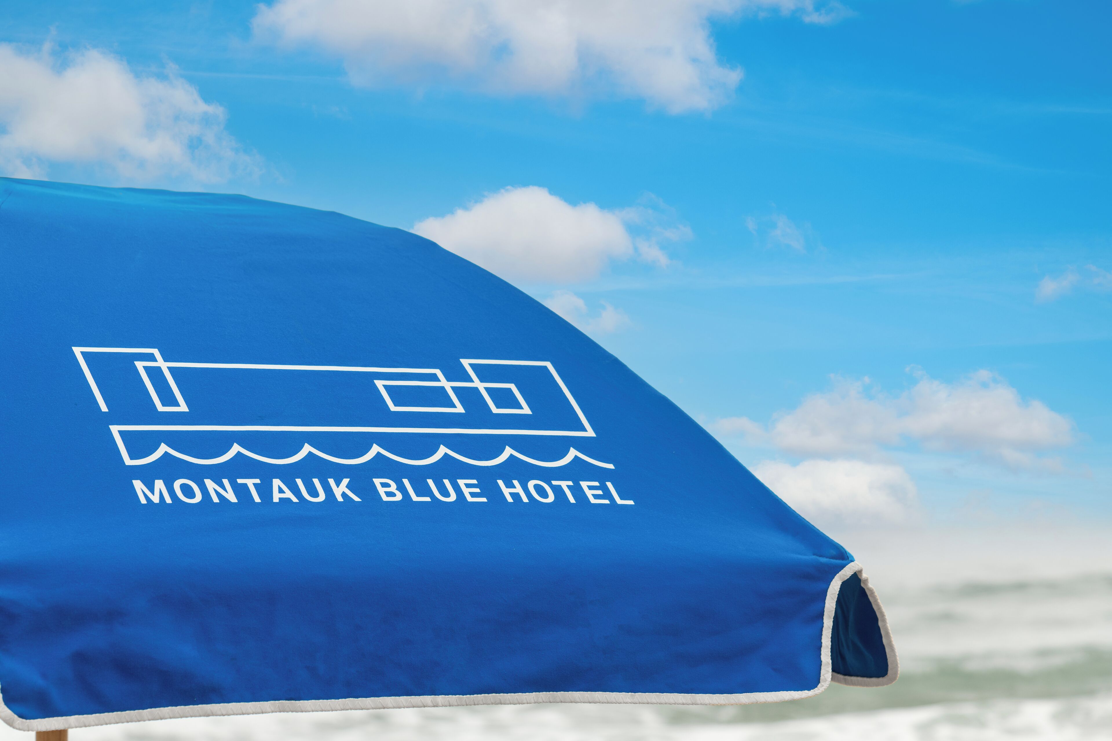 A blue umbrella with the text "Montaouk Blue Hotel" and a hotel icon.