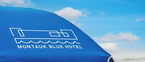A blue umbrella with the text "Montaouk Blue Hotel" and a hotel icon.