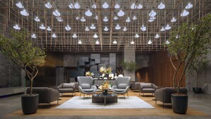 A modern interior with a geometric ceiling design, multiple seating areas, and potted plants. - InterContinental Presidente Monterrey by IHG (San Pedro Garza García)