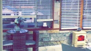 A room with a stone wall, a fireplace, and a dining area with a table and chairs. - Bring Your Own Boat - Meticulously restored house on the Potomac River  (Hedgesville)