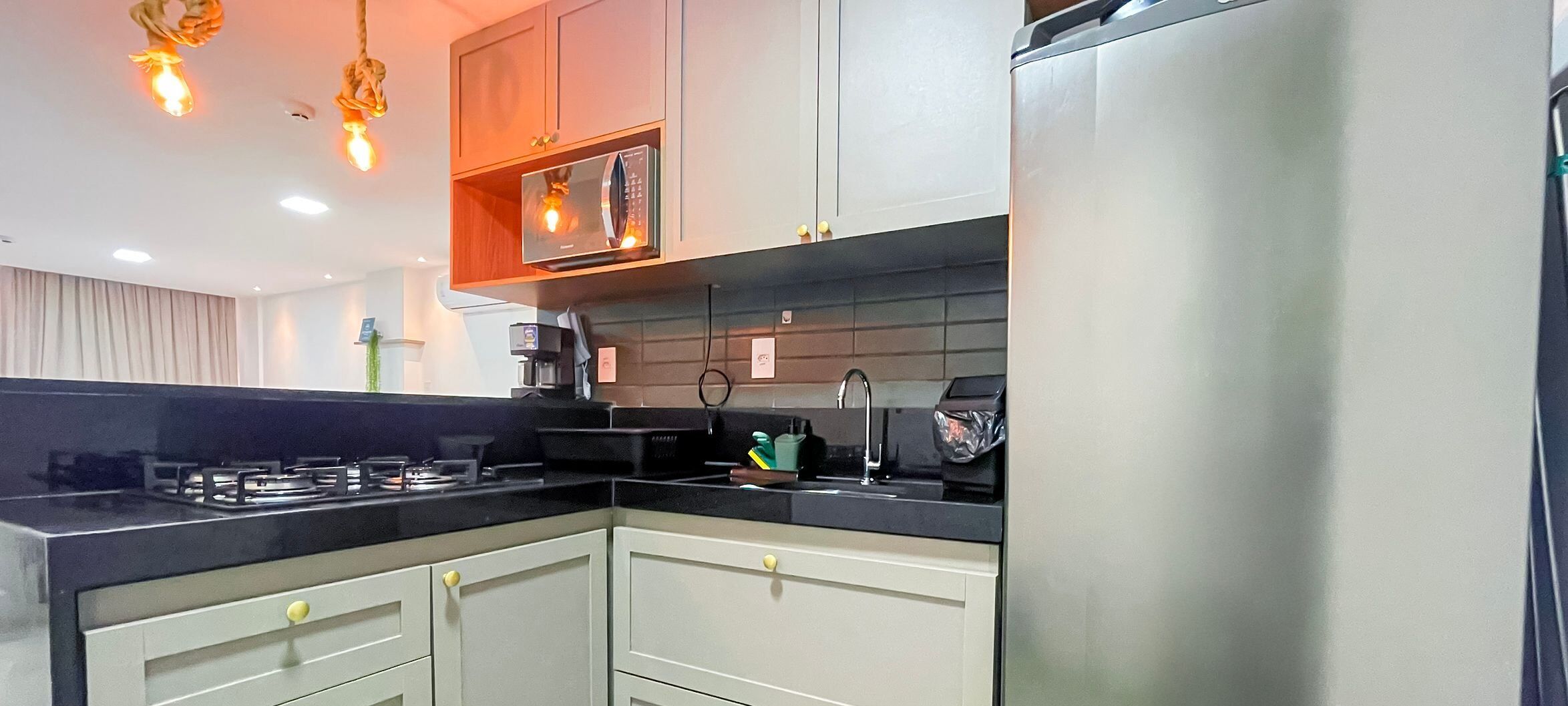 A modern kitchen with a gas stove, microwave, and stainless steel refrigerator.