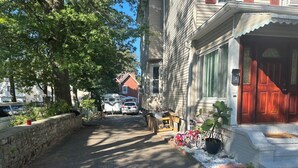 A narrow street with houses on both sides, a stone wall on the left, and a red door on the right. - ZO Family Cottage  (Mount Vernon)