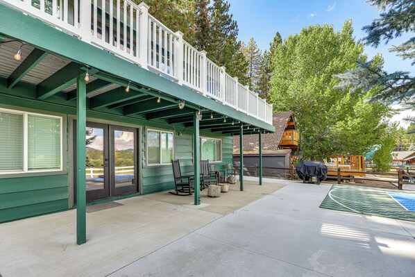 Un patio couvert avec des meubles d’extérieur et un barbecue.