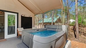 A hot tub under a canopy, surrounded by trees, with a view of a forest. - Loblolly Pine Luxury Glamping Tent Suite at Starlight Haven Resort (Hot Springs)