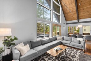 Una sala de estar moderna con un amplio sofá modular, una mesa de centro y una lámpara de pie.
